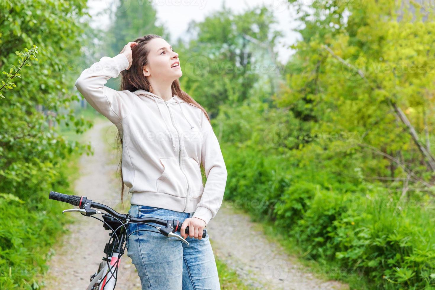 junge frau, die fahrrad im sommerstadtpark draußen fährt. aktive Menschen. Hipster-Mädchen entspannen und Fahrrad fahren foto