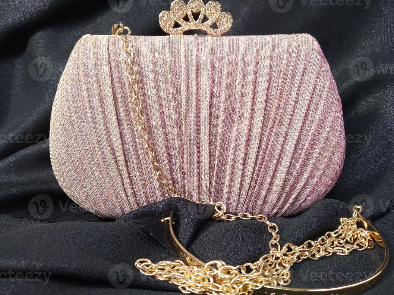 die pink leuchtende tasche sieht elegant aus mit einem goldfarbenen kettenriemen, der sich für partys oder einladungen eignet foto