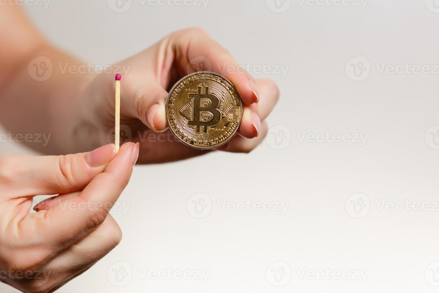 Bitcoin in der Hand auf weißem Hintergrund Streichholz, Feuer, Flamme, Brennen foto