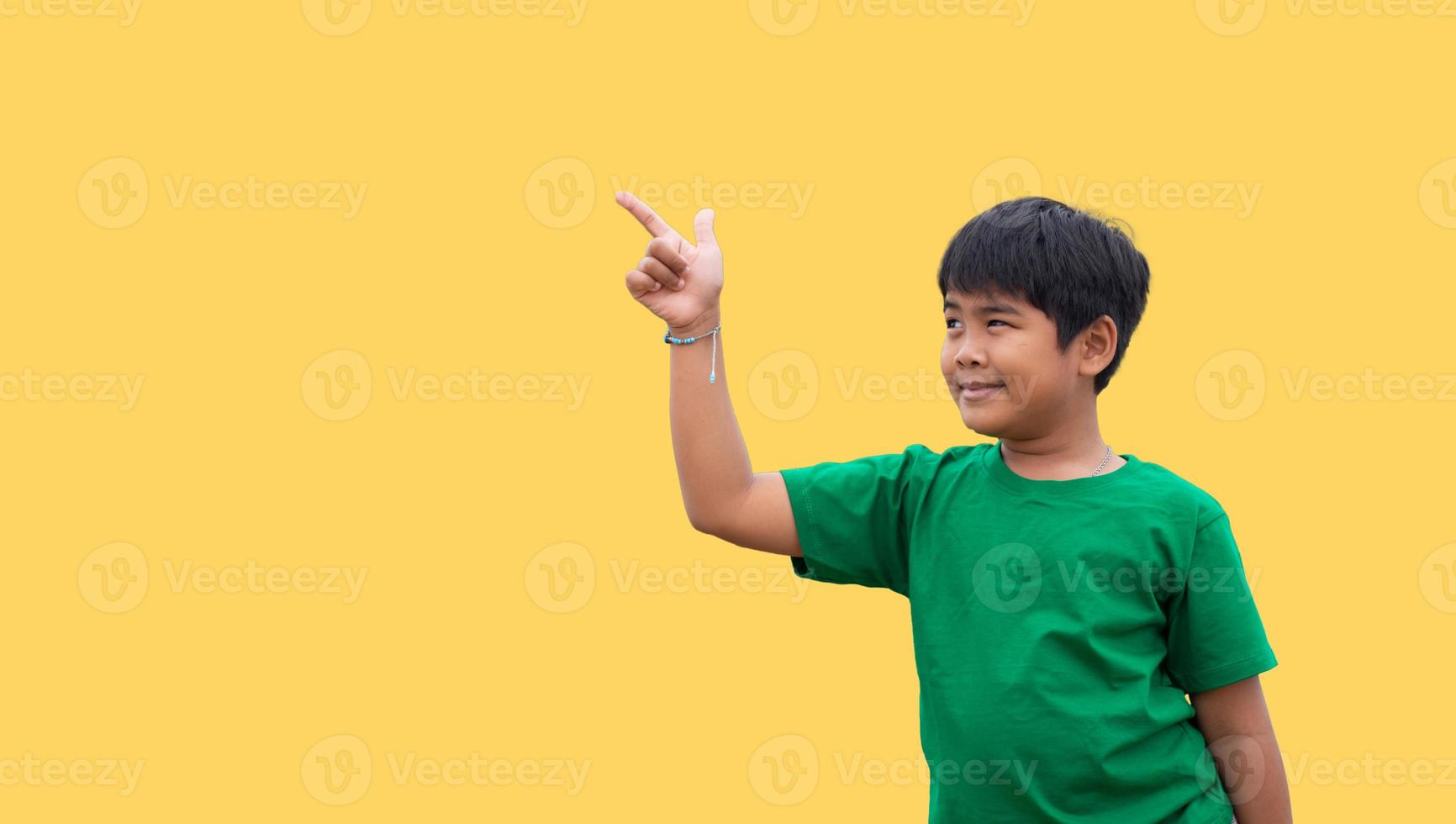 Der Junge lächelte und wies mit der Hand auf seine Seite. auf gelbem Grund foto
