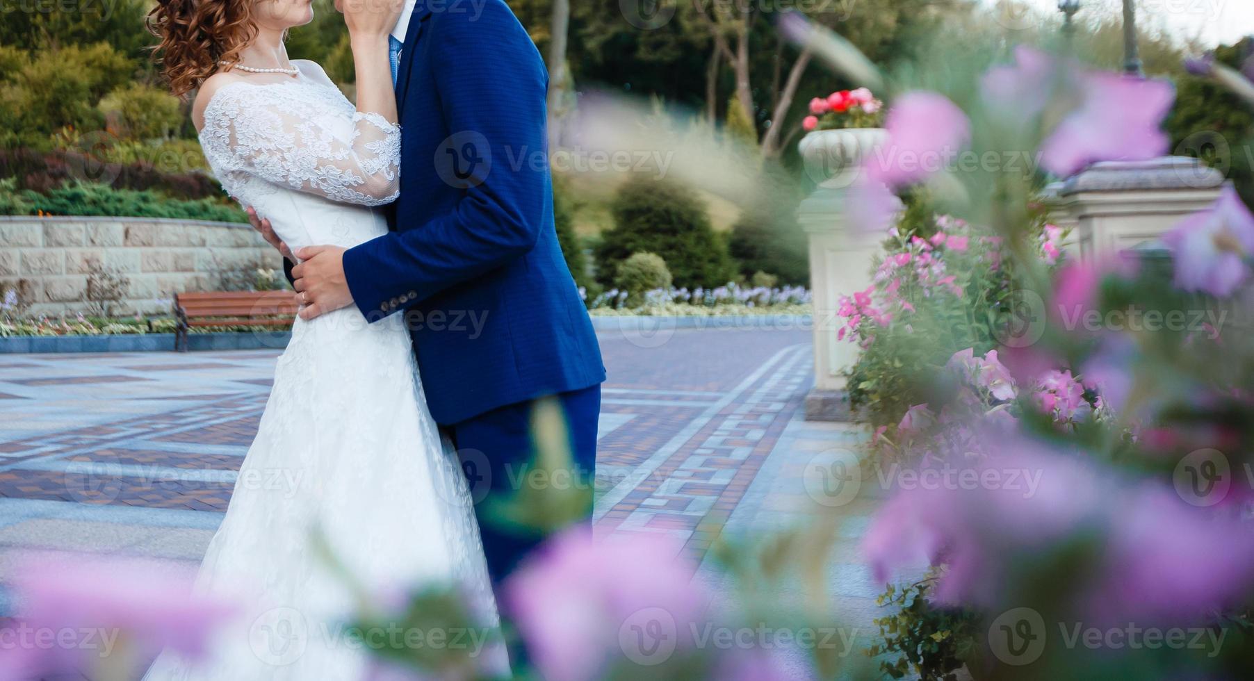 braut und bräutigam am hochzeitstag zu fuß im freien auf frühling natur brautpaar glücklich frischvermählten foto