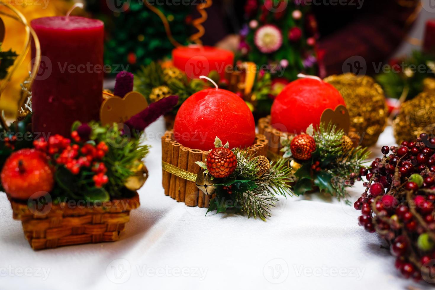 kerze verziert mit zimtstangen und roten äpfeln, weihnachtsdekoration foto