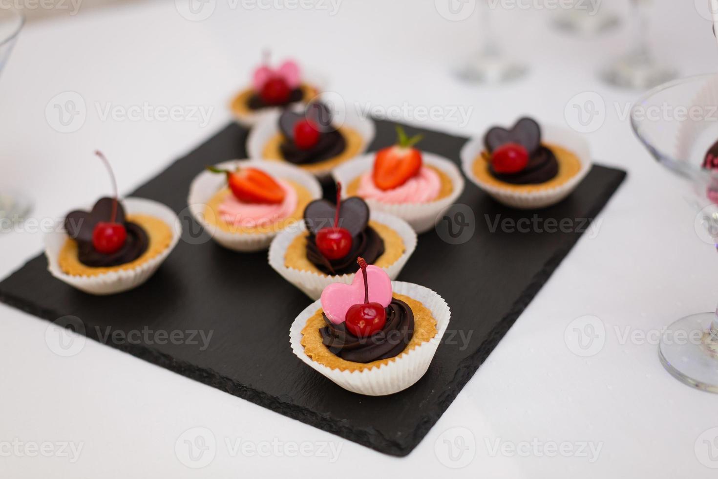 Köstliche Schokoladen-Cupcakes mit Beeren auf weißem Tisch, Draufsicht foto