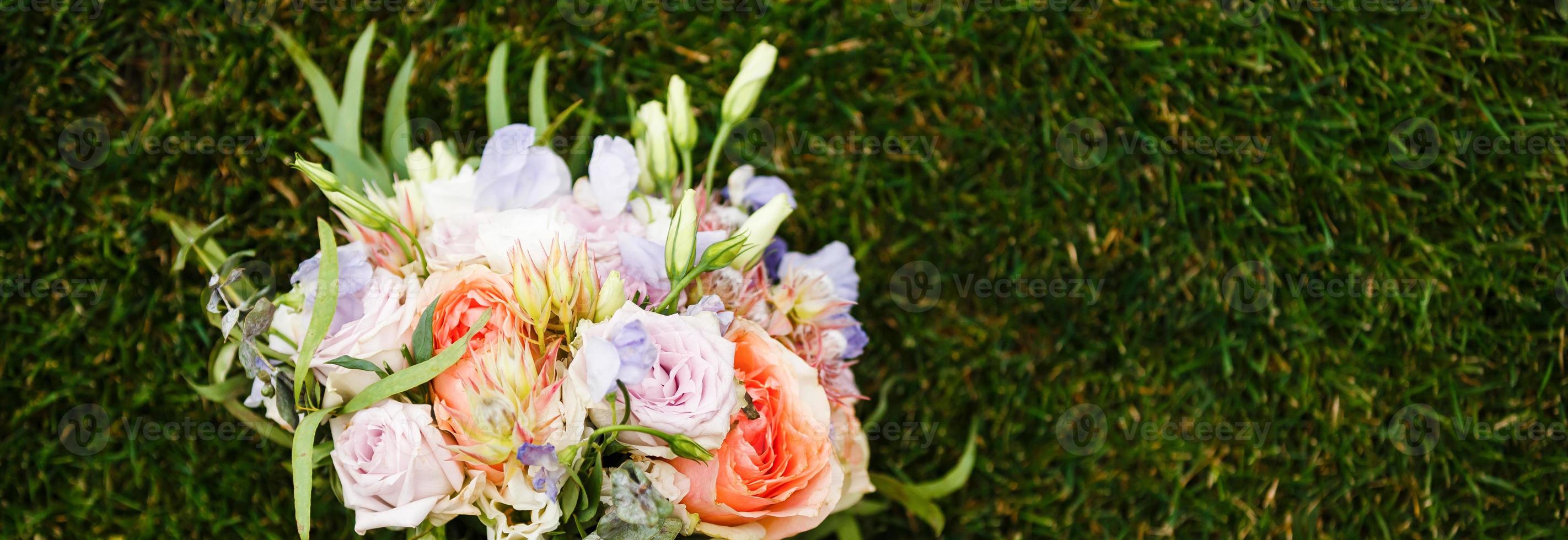 Brautstrauß. der Brautstrauß. Blumenstrauß aus weißen, rosa und grünen Farben mit pastellfarbenen Seidenbändern auf Grashintergrund foto