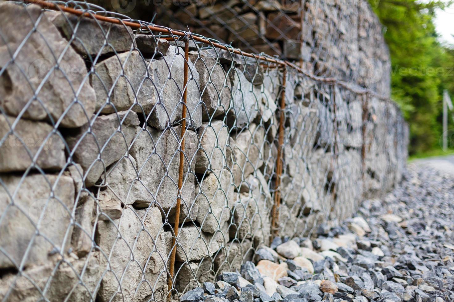Böschungs- und Erdstützmauermanagement mit Felsen und Maschendrahtkäfigsystem in tropischem hügeligem Gelände foto