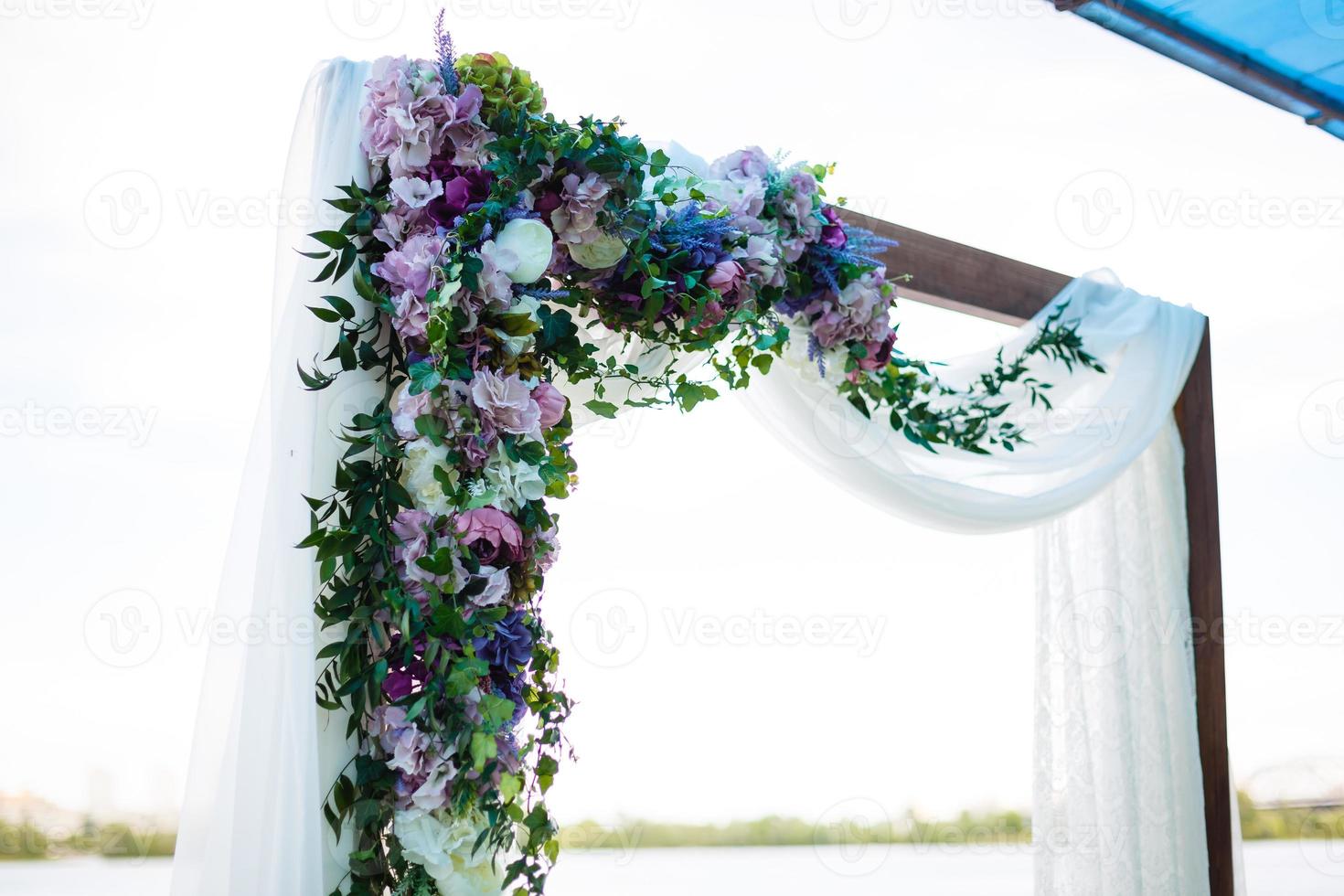 Bogen für die Hochzeitszeremonie, geschmückt mit Stoff und Blumen foto