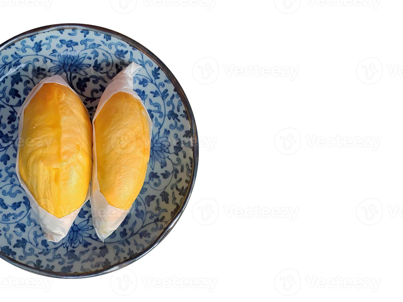Zwei von goldgelber Farbe Durian-Fleisch, eingewickelt mit weißem Papier auf der blauen antiken Platte, König der Früchte, natürliche Form und Form, isoliert, weißer Hintergrund mit Beschneidungspfad foto