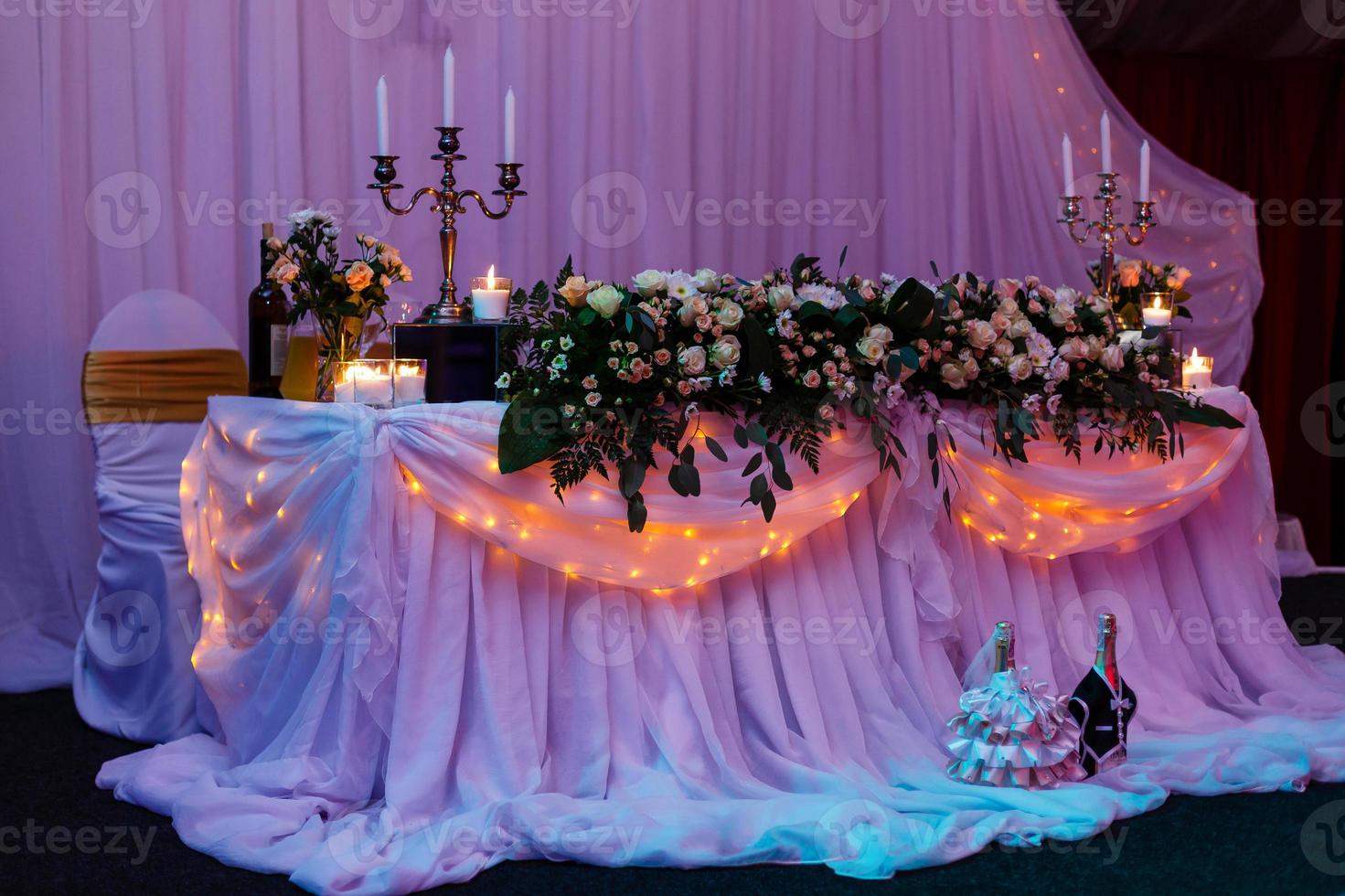 schönes Hochzeitsrestaurant für die Ehe. weißes Dekor für Braut und Bräutigam. bunte Dekoration zum Feiern. Schönheit Braut Interieur. Blumenstrauß, Lebensmittel und Blumen in der Halle foto