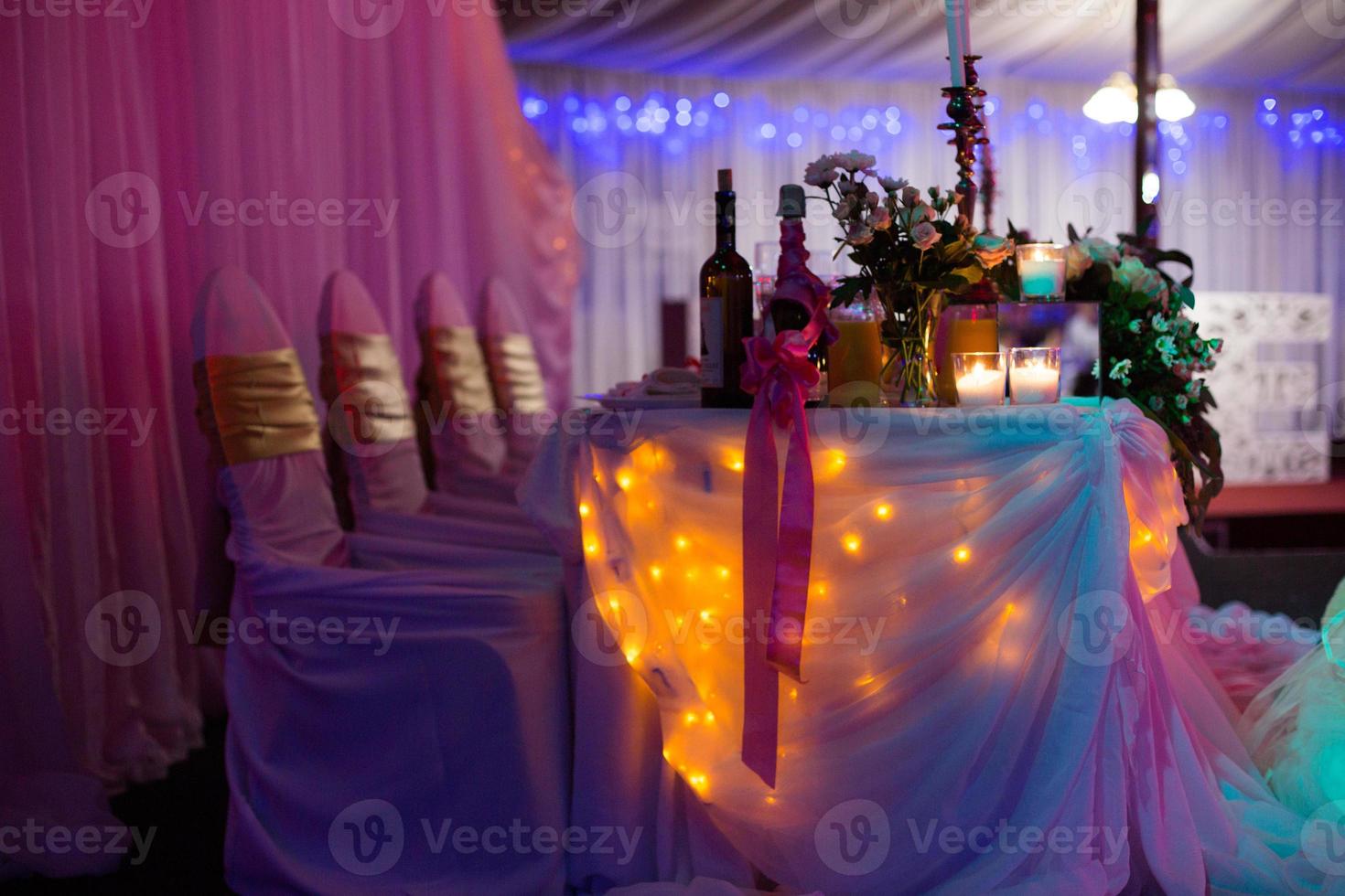 schönes Hochzeitsrestaurant für die Ehe. weißes Dekor für Braut und Bräutigam. bunte Dekoration zum Feiern. Schönheit Braut Interieur. Blumenstrauß, Lebensmittel und Blumen in der Halle foto