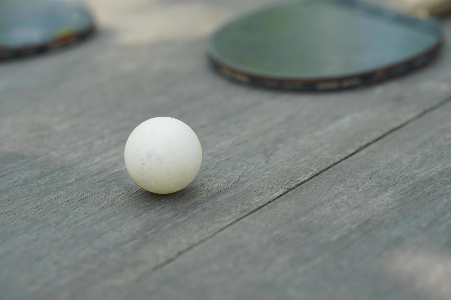 Tischtennisschlaufen und Schläger auf Holztisch foto