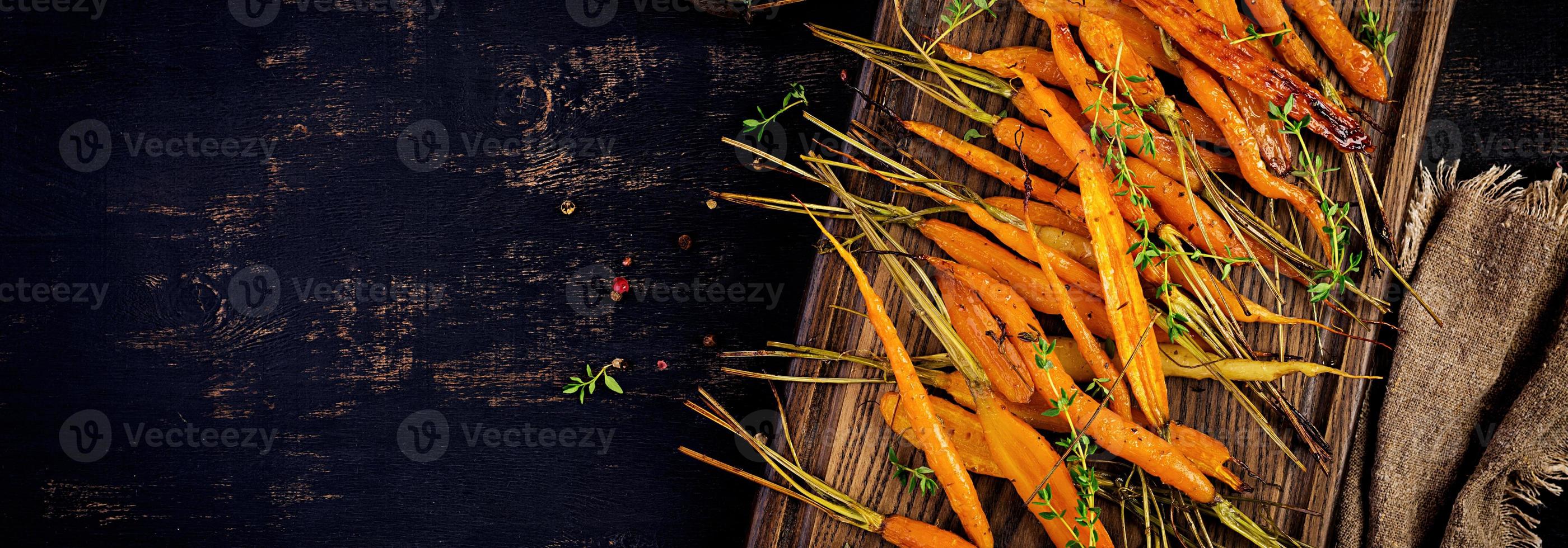 gebackene Bio-Karotten mit Thymian, Honig und Zitrone. Bio veganes Essen. Banner. Ansicht von oben foto