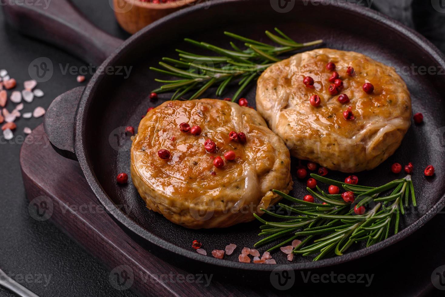 gegrillte Frikadellen mit Gewürzen und Kräutern oder Crepinette auf einem schwarzen Teller foto