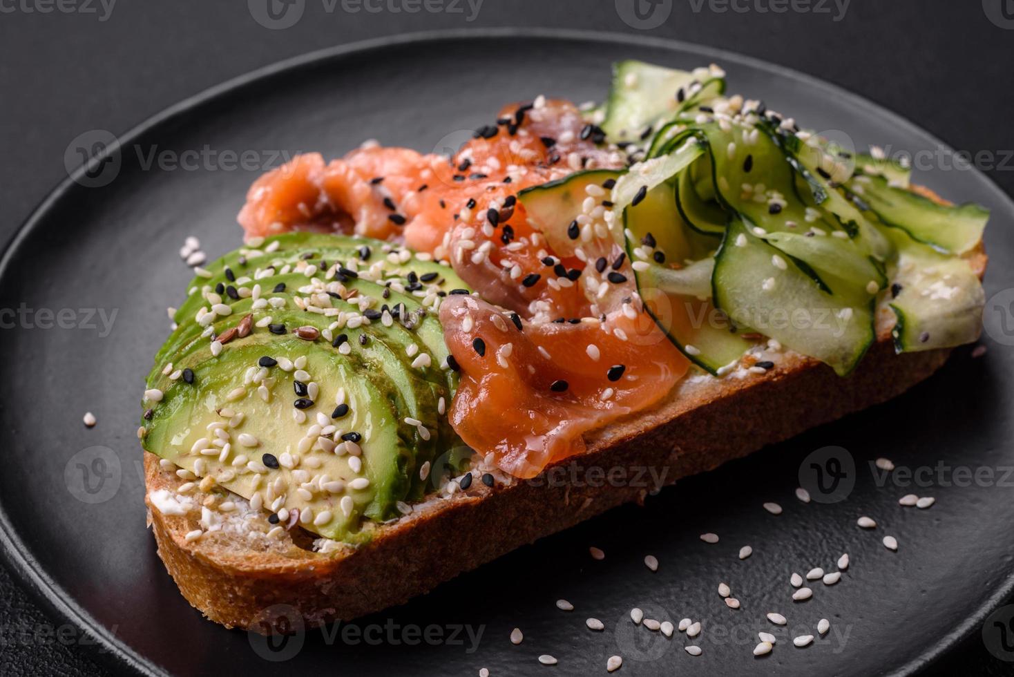 frisches leckeres Sandwich mit Lachs, Avocado und Sesam und Leinsamen foto