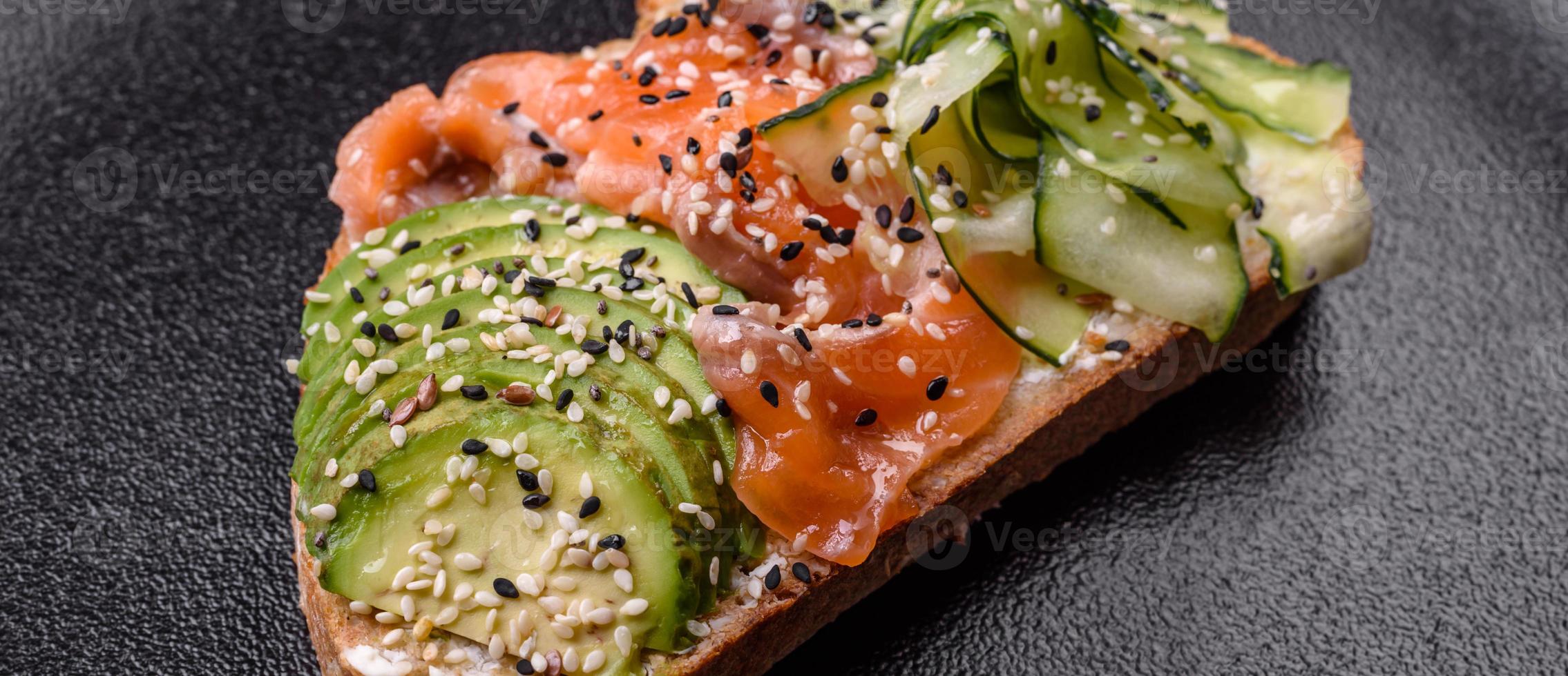 frisches leckeres Sandwich mit Lachs, Avocado und Sesam und Leinsamen foto