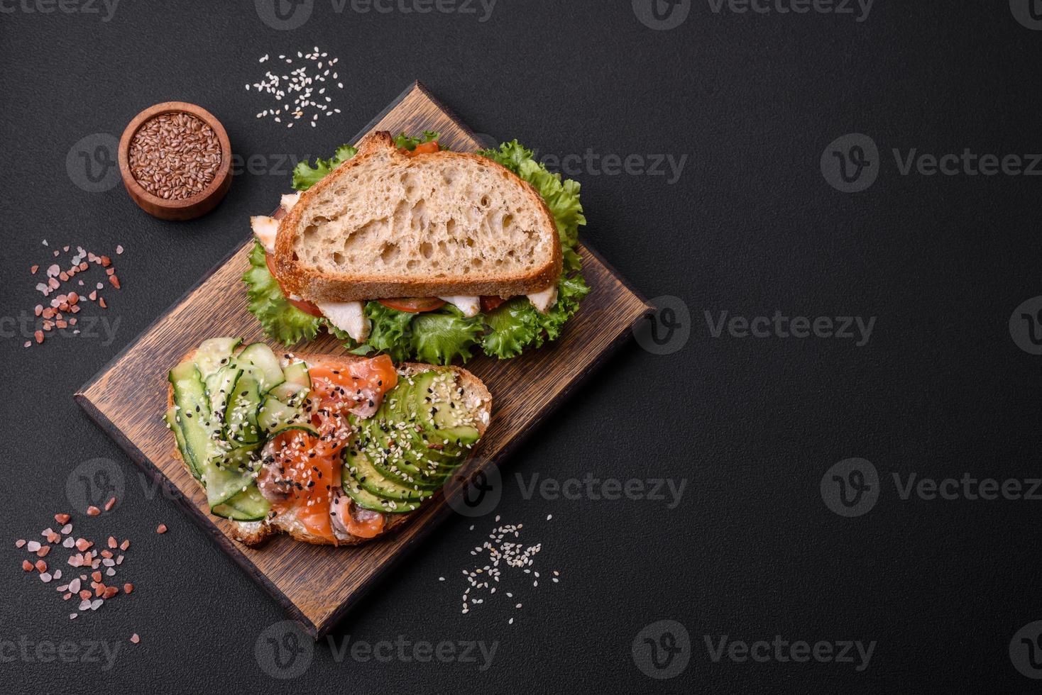 frisches leckeres Sandwich mit Lachs, Avocado und Sesam und Leinsamen foto