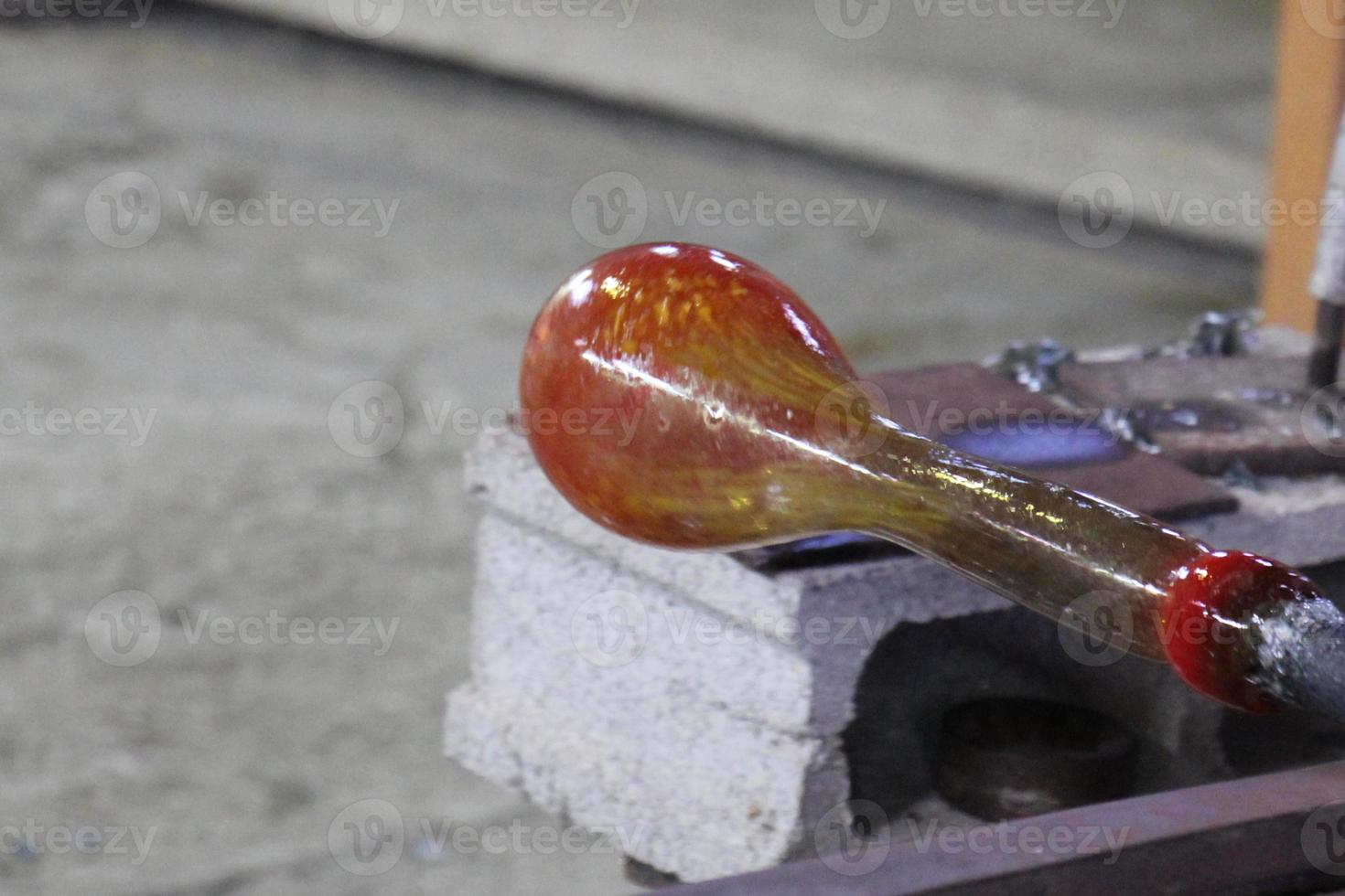 Der Meister arbeitet mit Glas in einer Glasfabrik. foto