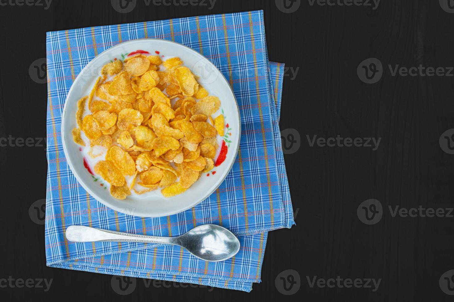 cornflakes mit milch auf schwarzer holztischplatteansicht foto