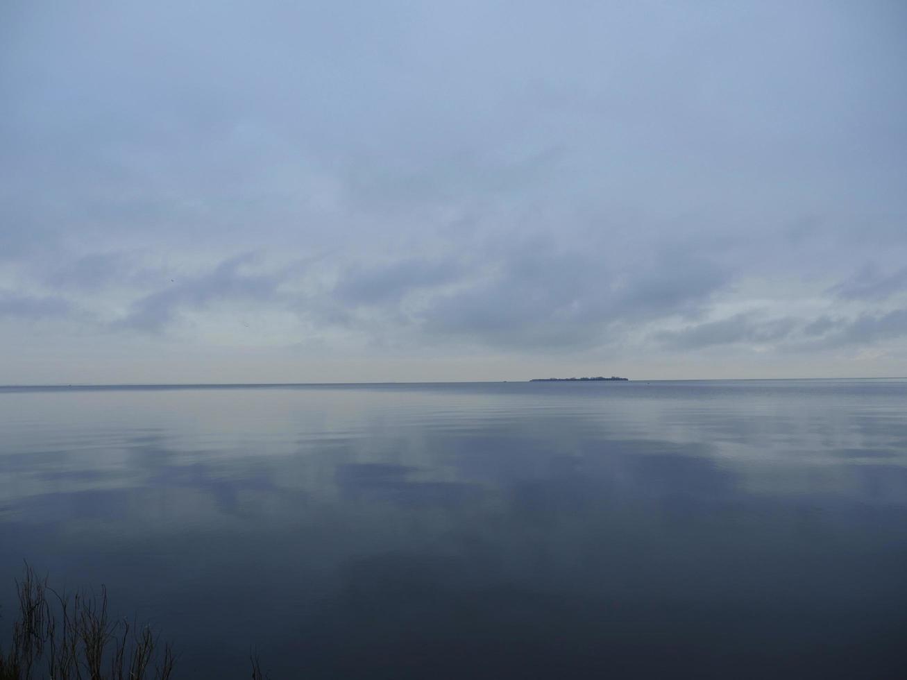 blick auf die insel am horizont düsteres herbstwetter, meerstück foto