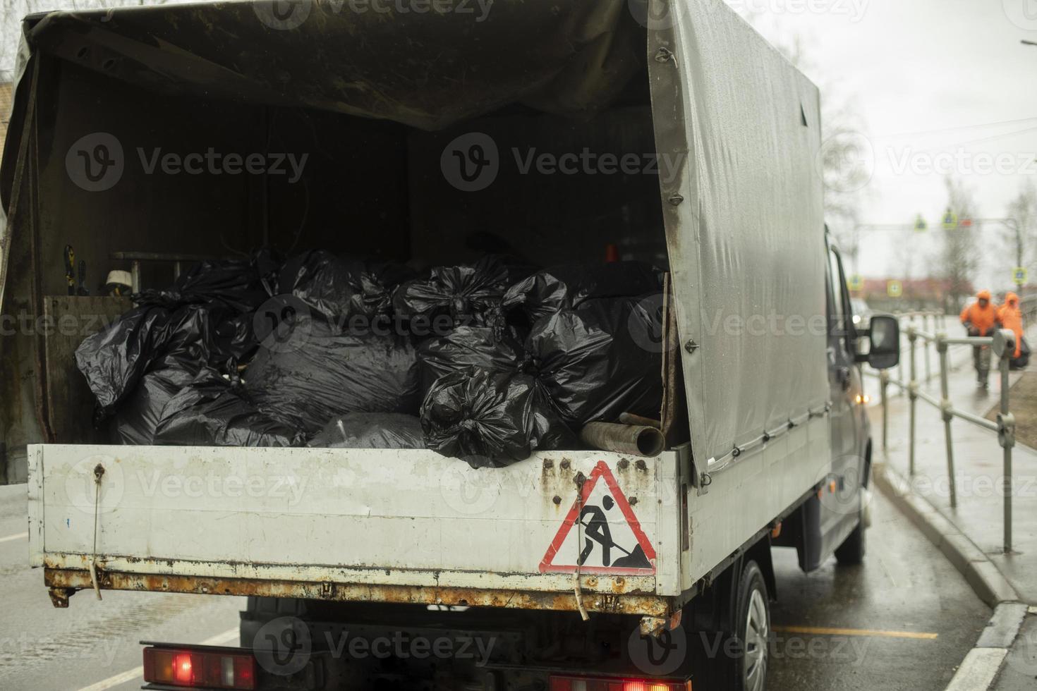 Müllsäcke hinter dem Auto. Transport von Abfällen in schwarzen Säcken. foto