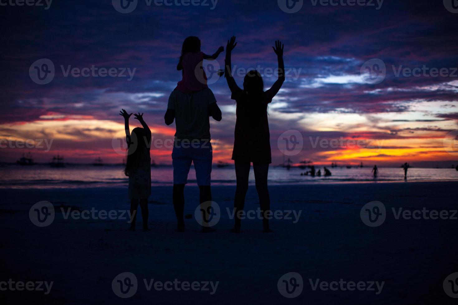 vierköpfige familie silhouette im sonnenuntergang am strand auf boracay foto