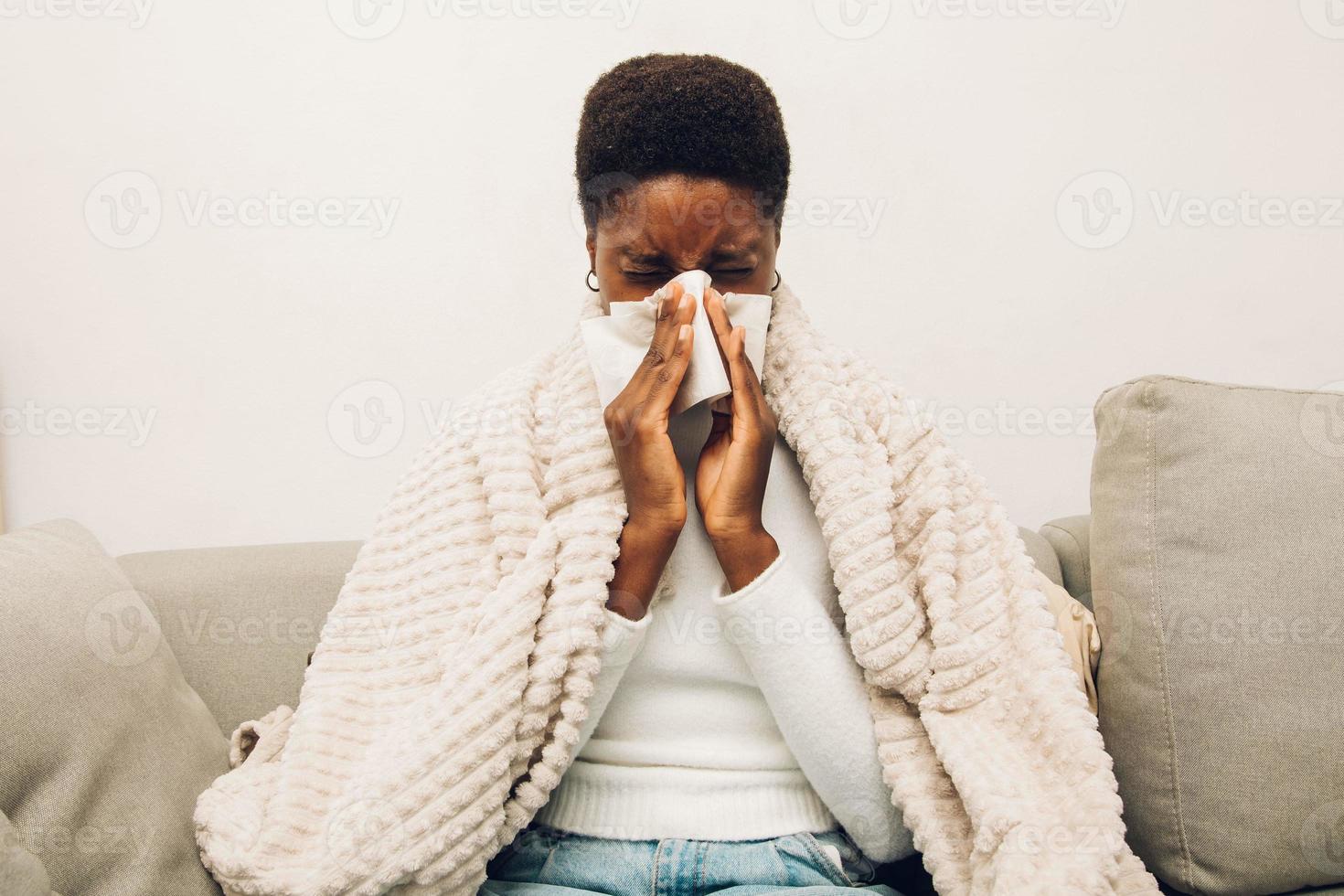 eine schwarze Frau, die sich die Nase putzt foto