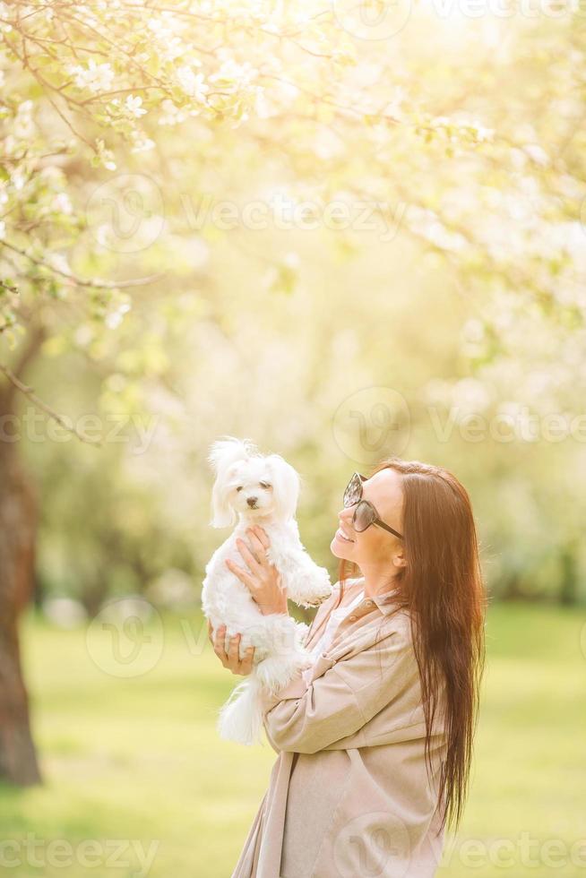 Frau spielt und umarmt Welpen im Park foto