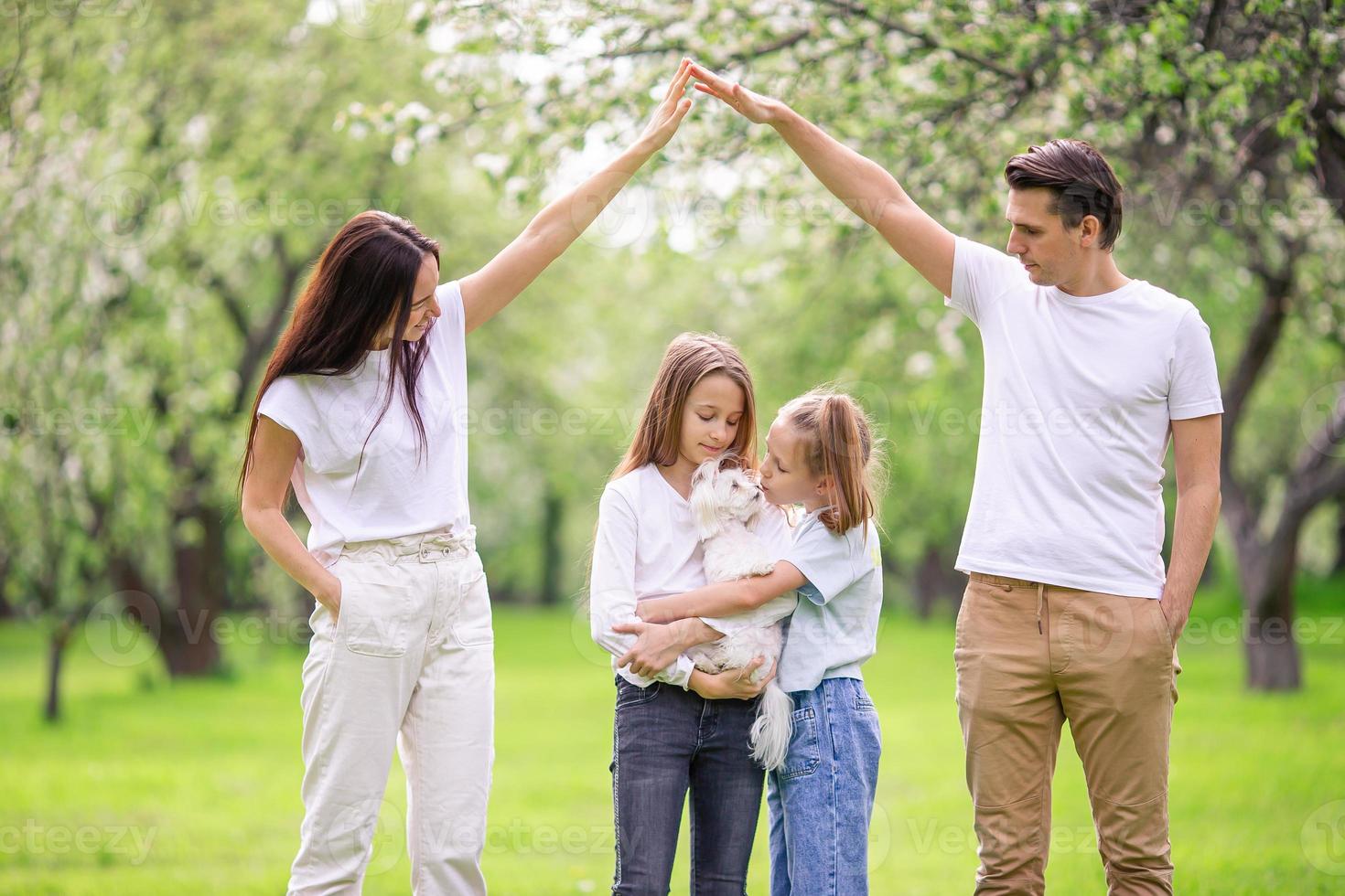 entzückende familie im blühenden kirschgarten am schönen frühlingstag foto