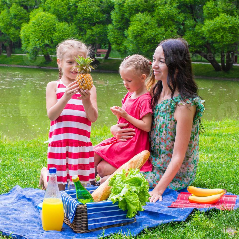 süßes kleines mädchen und glückliche mutter picknicken im park foto