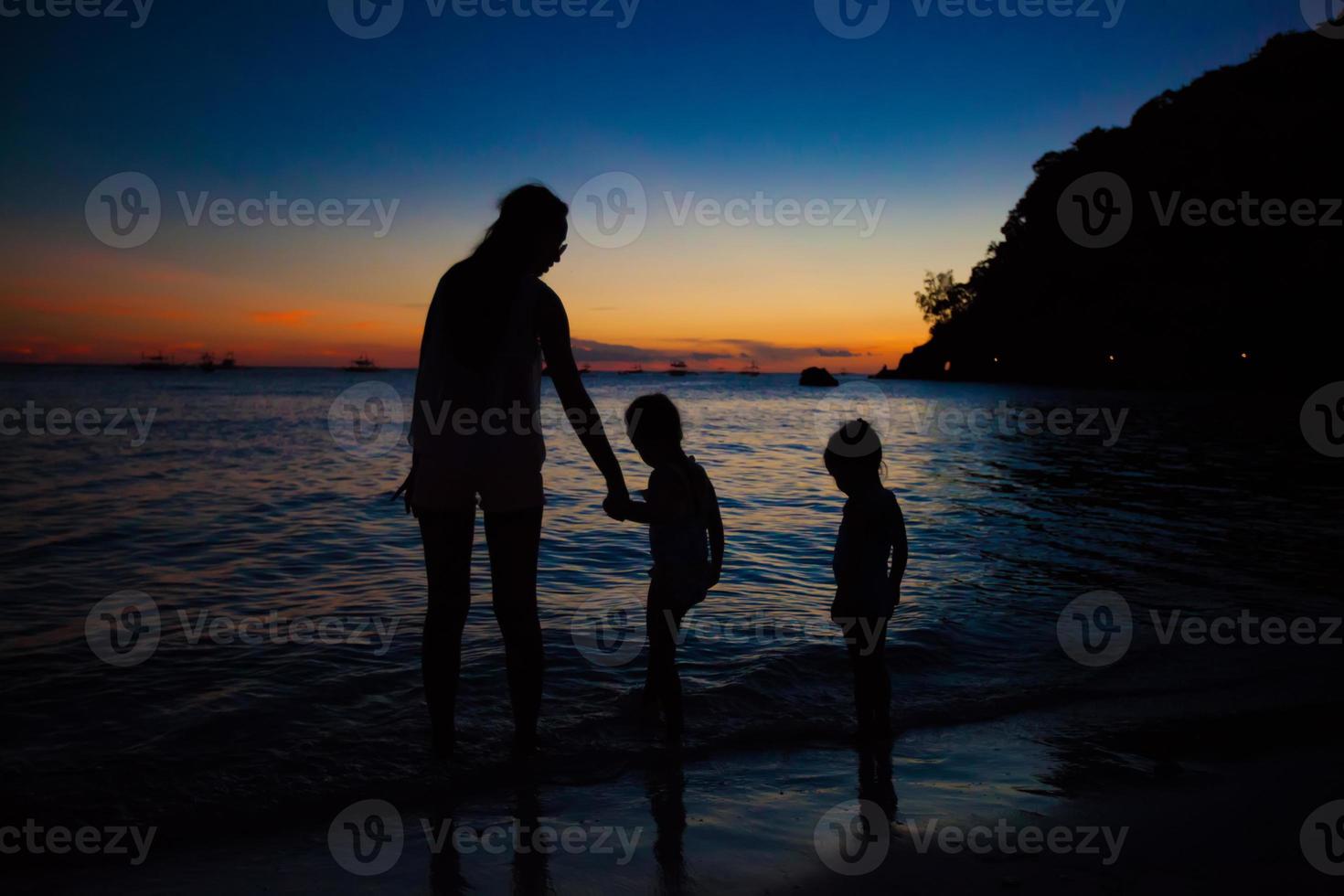 Familie von drei Silhouette im Sonnenuntergang am Strand von Boracay foto