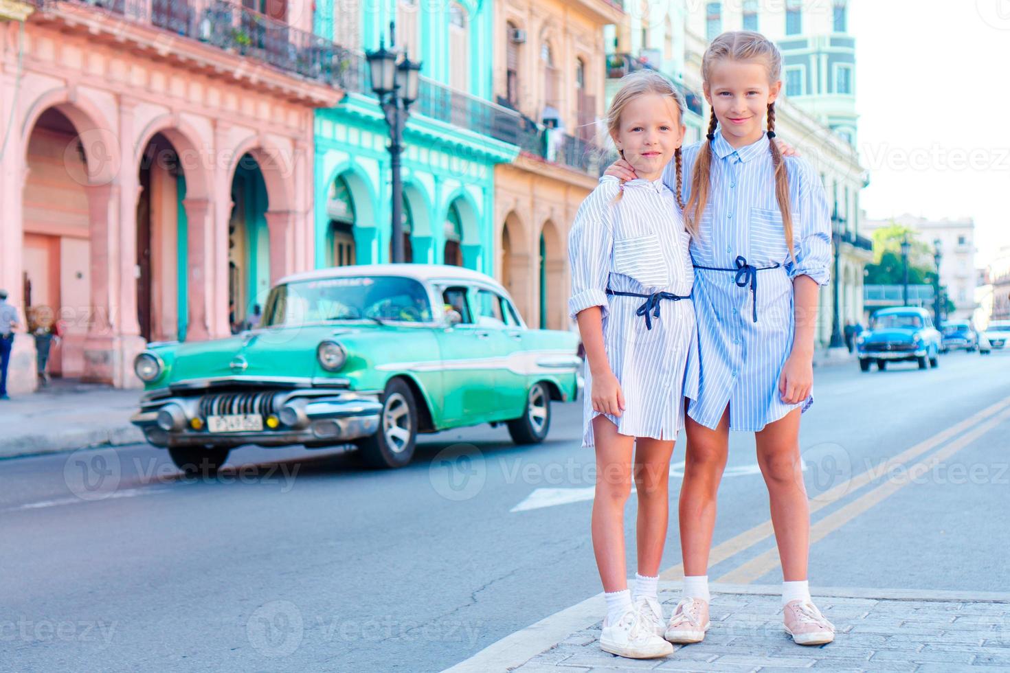 entzückendes kleines Mädchen in der beliebten Gegend in der Altstadt von Havanna, Kuba. Porträt von zwei Kindern im Freien auf einer Straße von Havanna foto