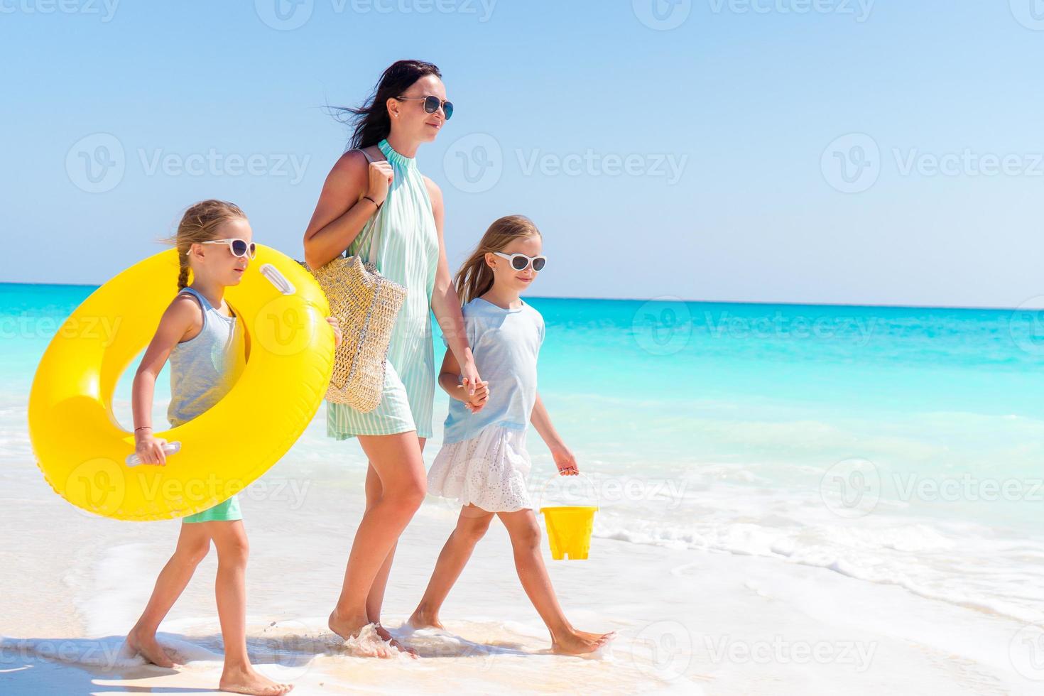 entzückende kleine Mädchen und junge Mutter am weißen Strand. foto