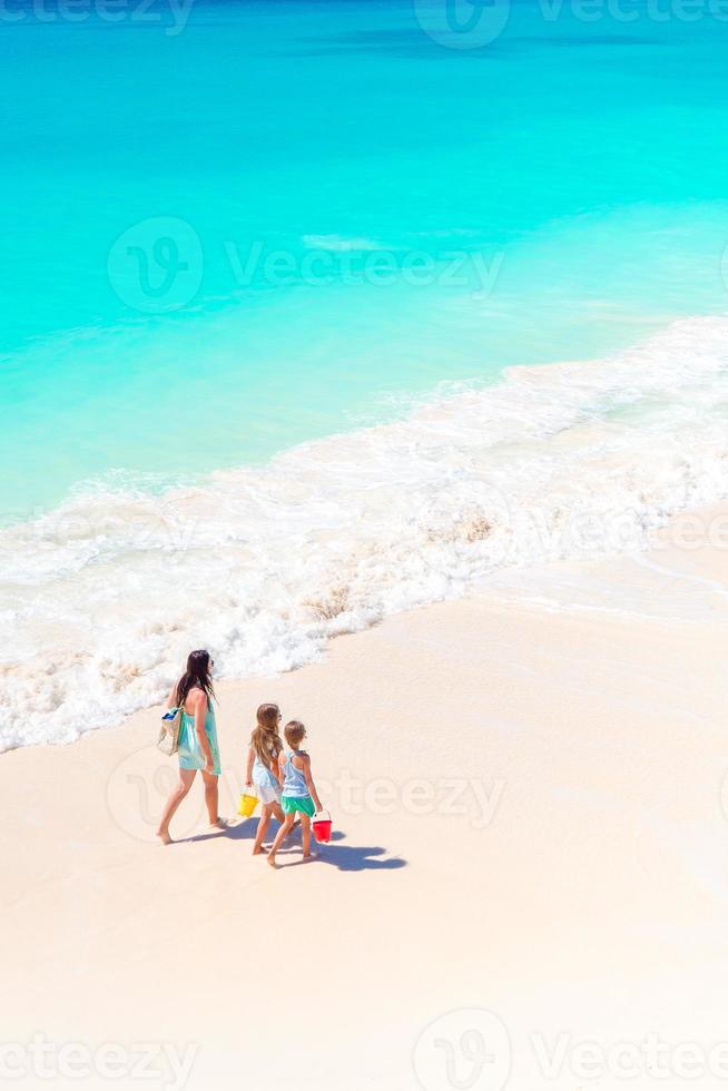 entzückende kleine Mädchen und junge Mutter am weißen Strand. foto