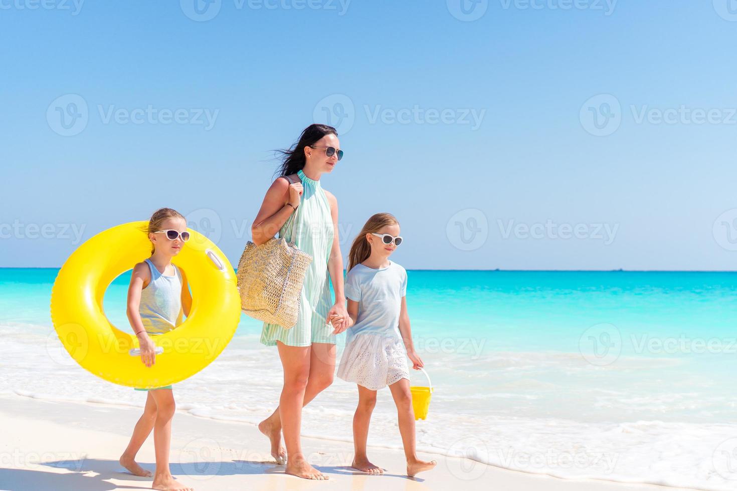 entzückende kleine Mädchen und junge Mutter am weißen Strand. foto