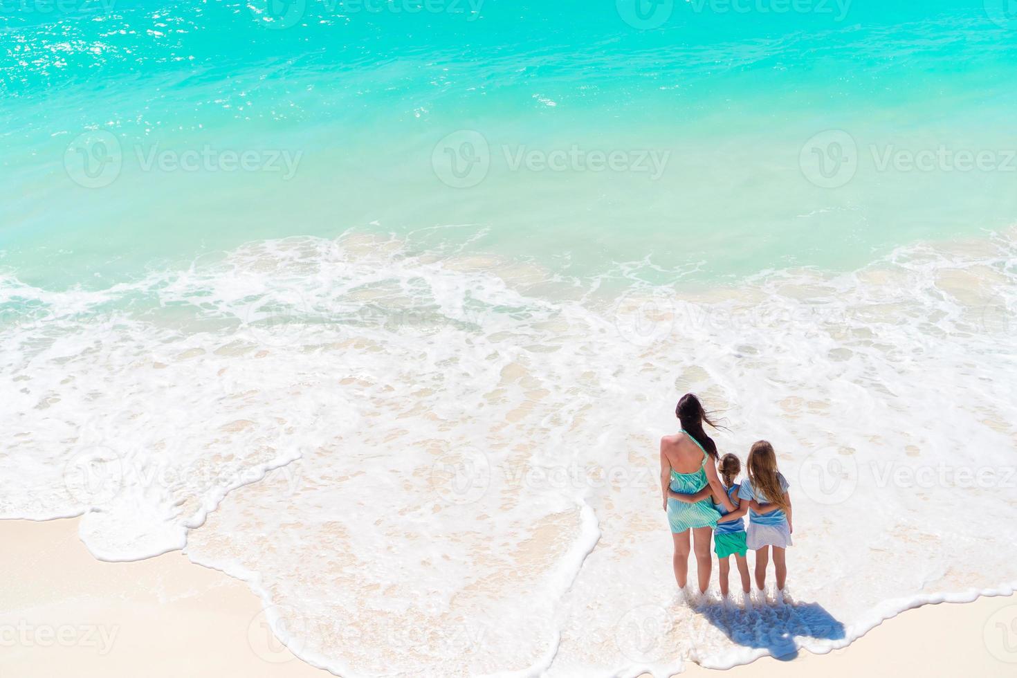 entzückende kleine Mädchen und junge Mutter am weißen Strand. foto