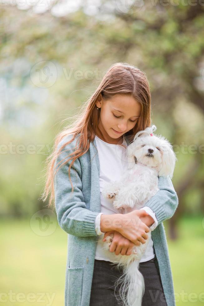 kleines lächelndes Mädchen, das im Park spielt foto