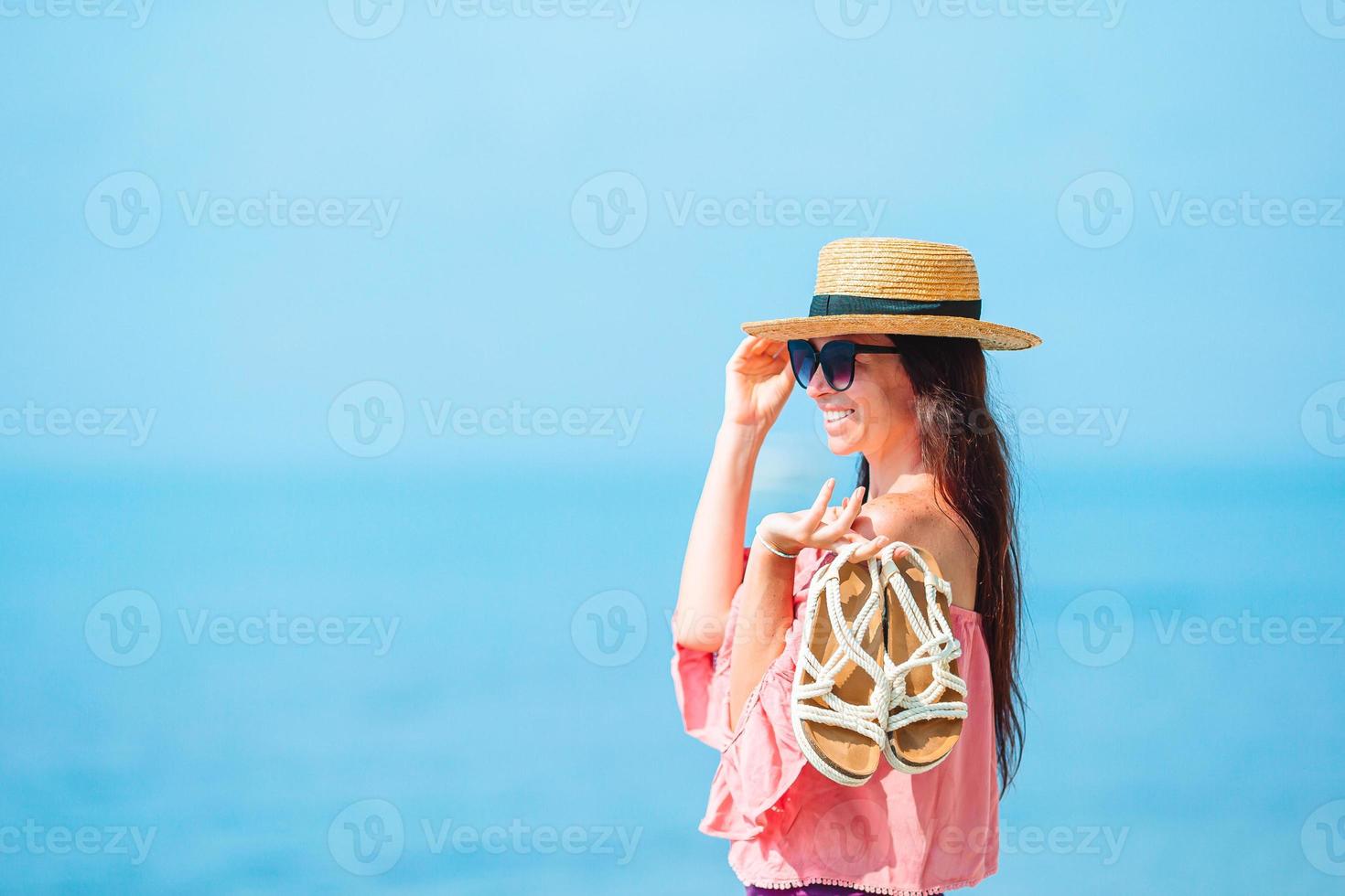 junge schöne Frau, die sich an der tropischen Küste amüsiert. glückliches Mädchen Hintergrund der blaue Himmel und das türkisfarbene Wasser im Meer foto