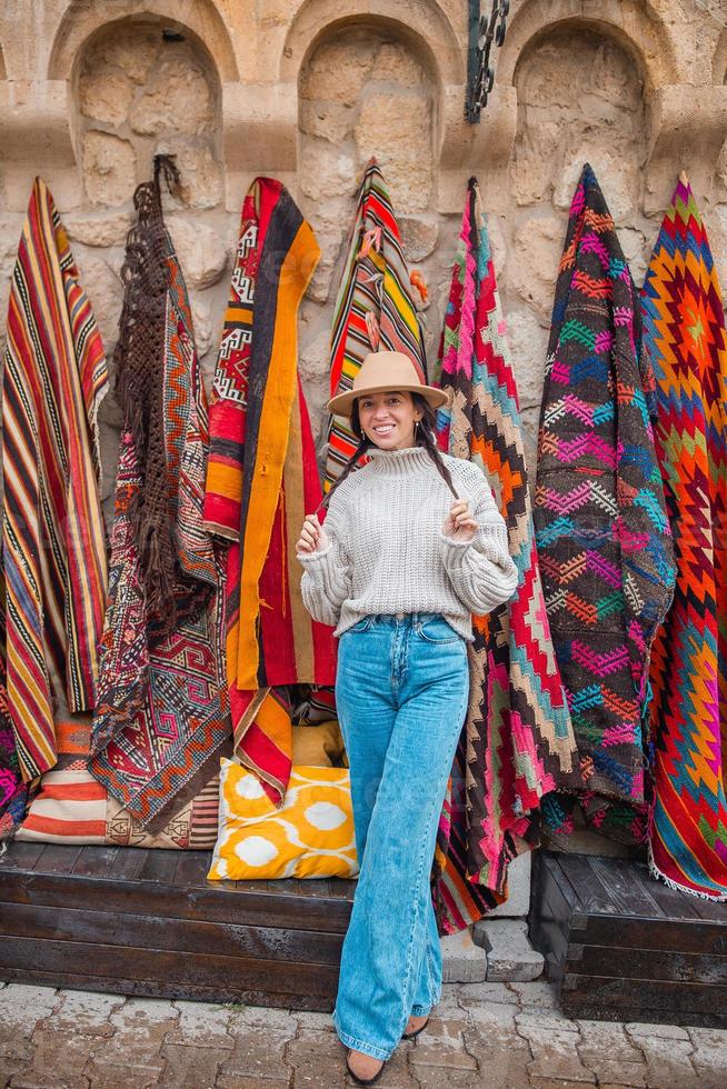 altes traditionelles türkisches teppichgeschäft im höhlenhaus kappadokien, türkei kapadokya. junge Frau im Urlaub in der Türkei foto