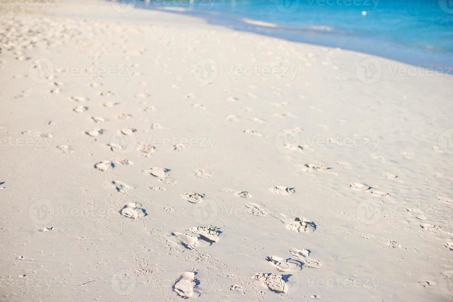 menschliche Fußabdrücke auf weißem Sand der karibischen Insel foto