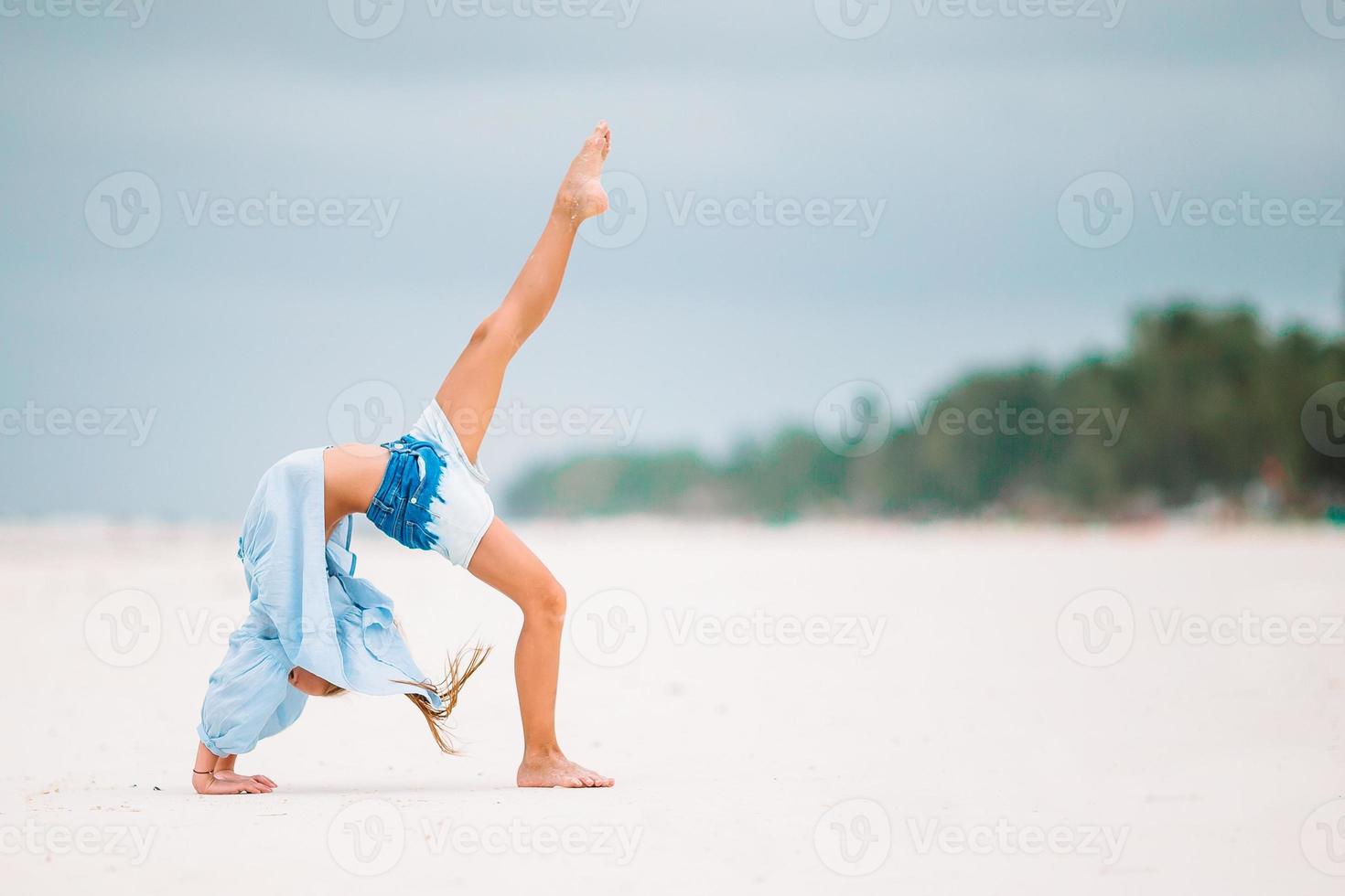 entzückendes glückliches kleines mädchen viel spaß im strandurlaub foto