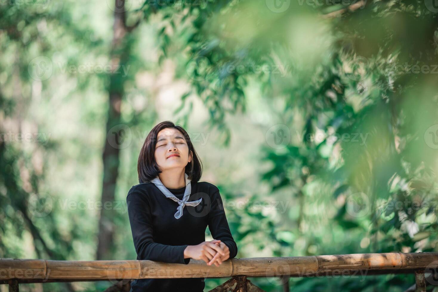 Protrait junge Frau, die beim Camping im Wald schöne Natur sieht foto