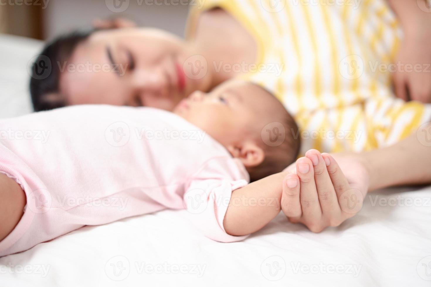 Muttererziehung und neugeborenes Geburtsleben. mutter und baby spielen im sonnigen schlafzimmer, familie hat spaß zusammen. kinderbetreuung, mutterschaftskonzept. foto