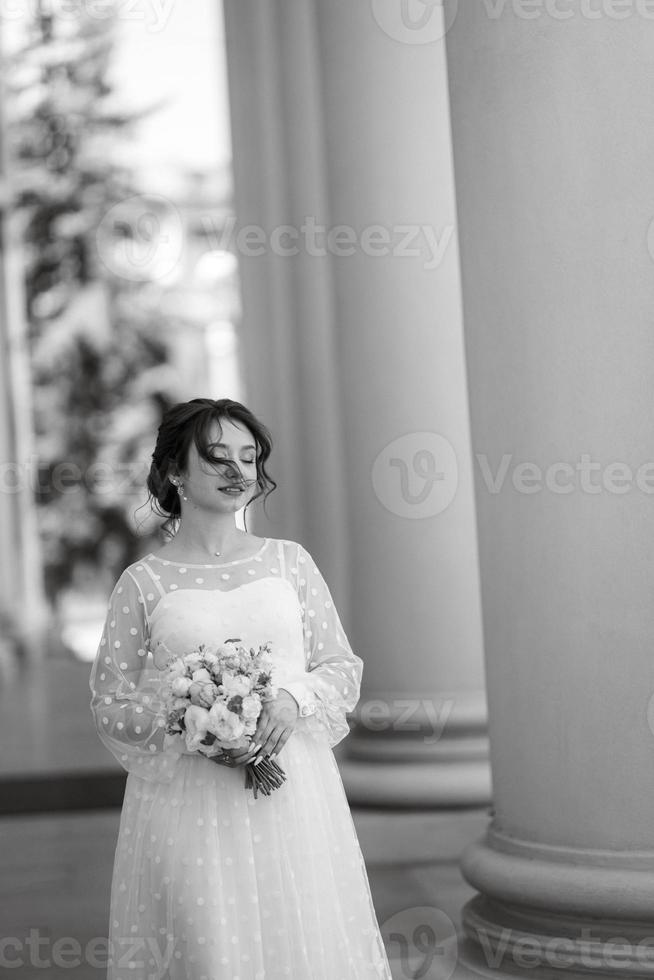 Porträt eines jungen Brautmädchens in einem leichten Kleid in einer städtischen Umgebung foto