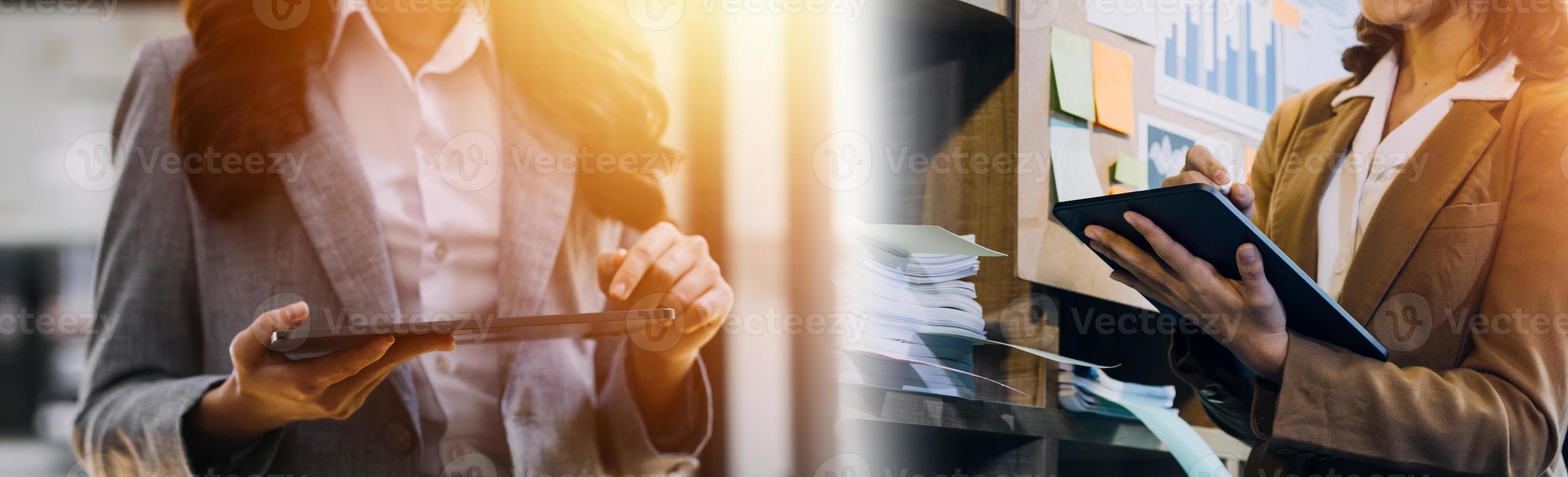 volle Konzentration bei der Arbeit. Gruppe junger Geschäftsleute, die zusammen mit im Hintergrund sitzenden Kollegen am Schreibtisch arbeiten und kommunizieren foto