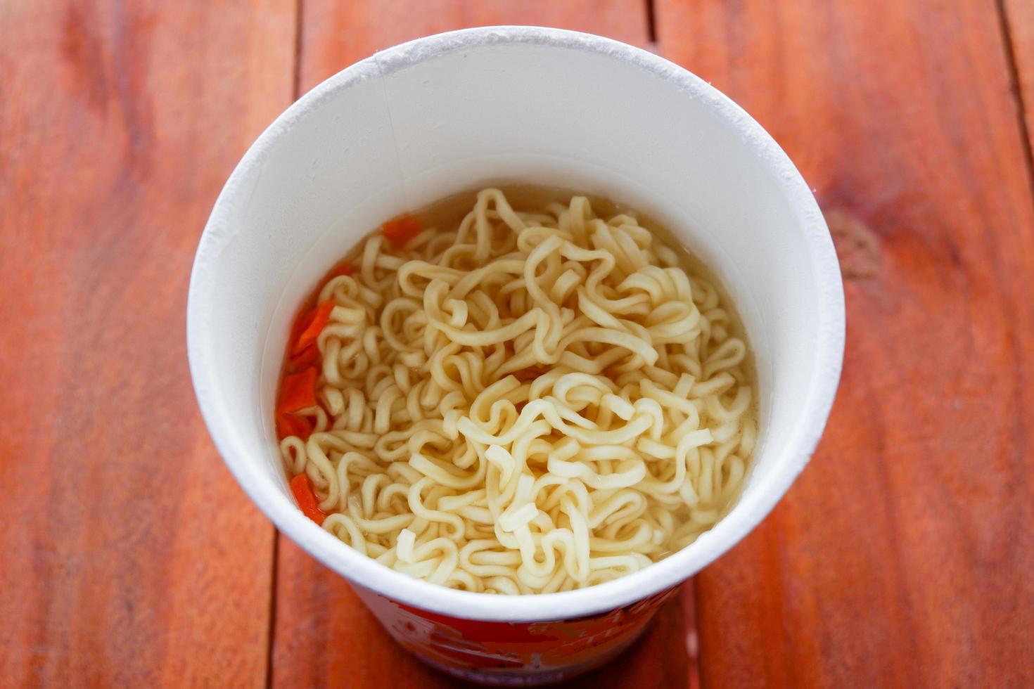 Instant-Nudeln gekocht, Instant-Ramen-Nudeln in einer Tasse kochen - Nudelsuppe auf Papierschüssel foto