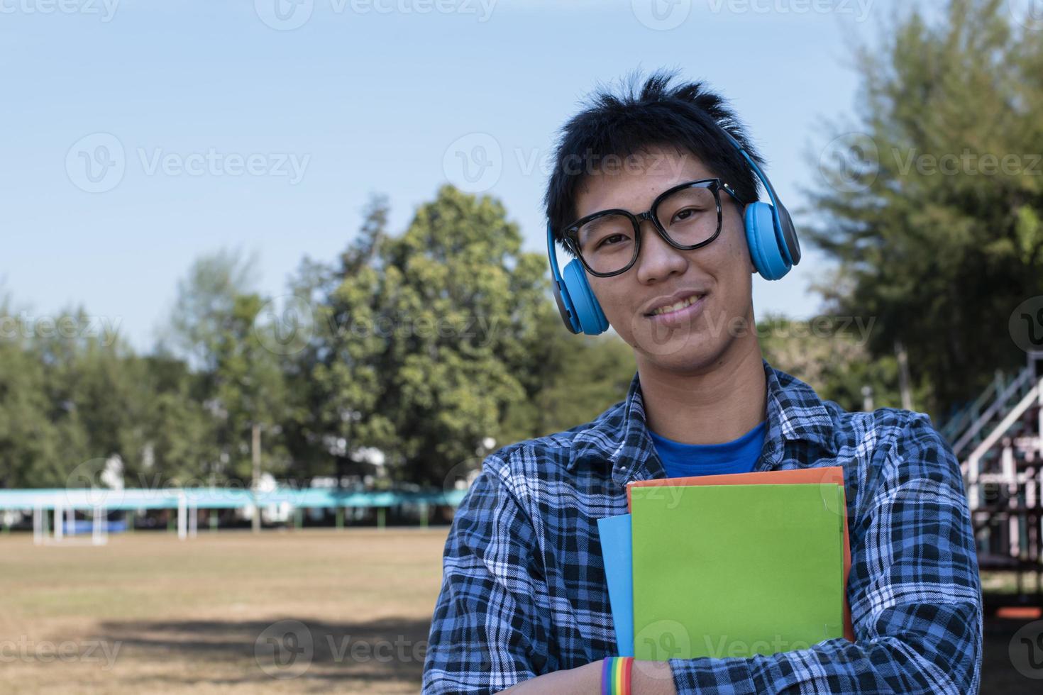 porträt junger asiatischer junge trägt ein regenbogenarmband und steht neben dem spielplatz der high school. foto