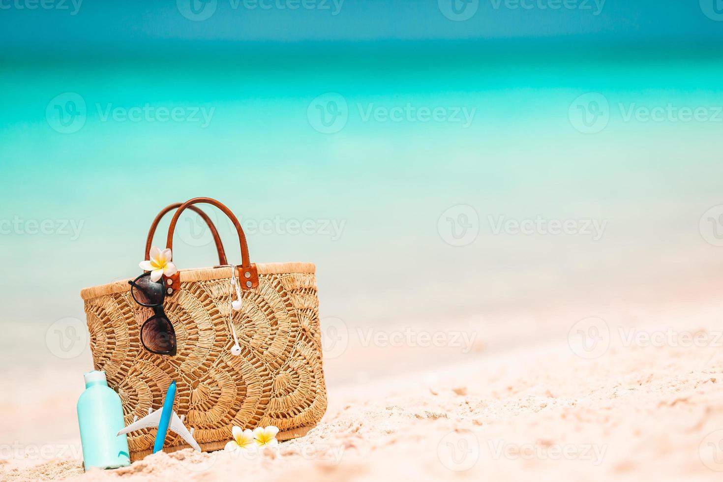 Strandzubehör - Strohsack, Hut und Sonnenbrille am Strand foto