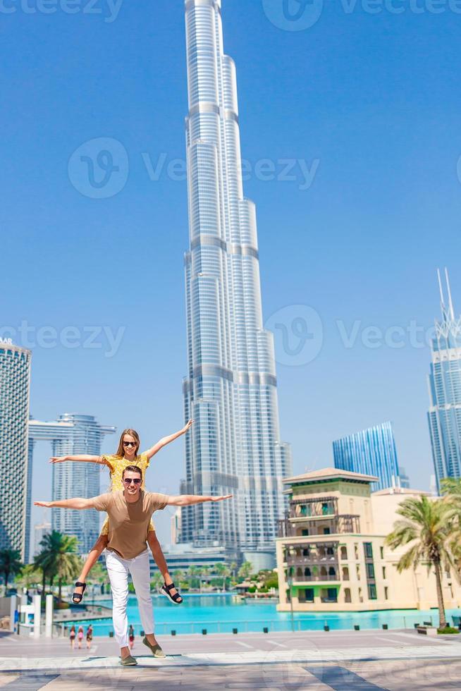 glückliche familie, die in dubai mit wolkenkratzern im hintergrund geht. foto