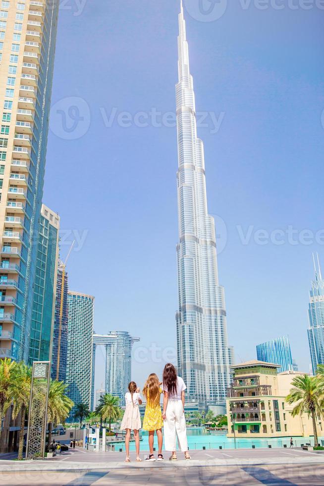 glückliche familie, die in dubai mit wolkenkratzern im hintergrund geht. foto