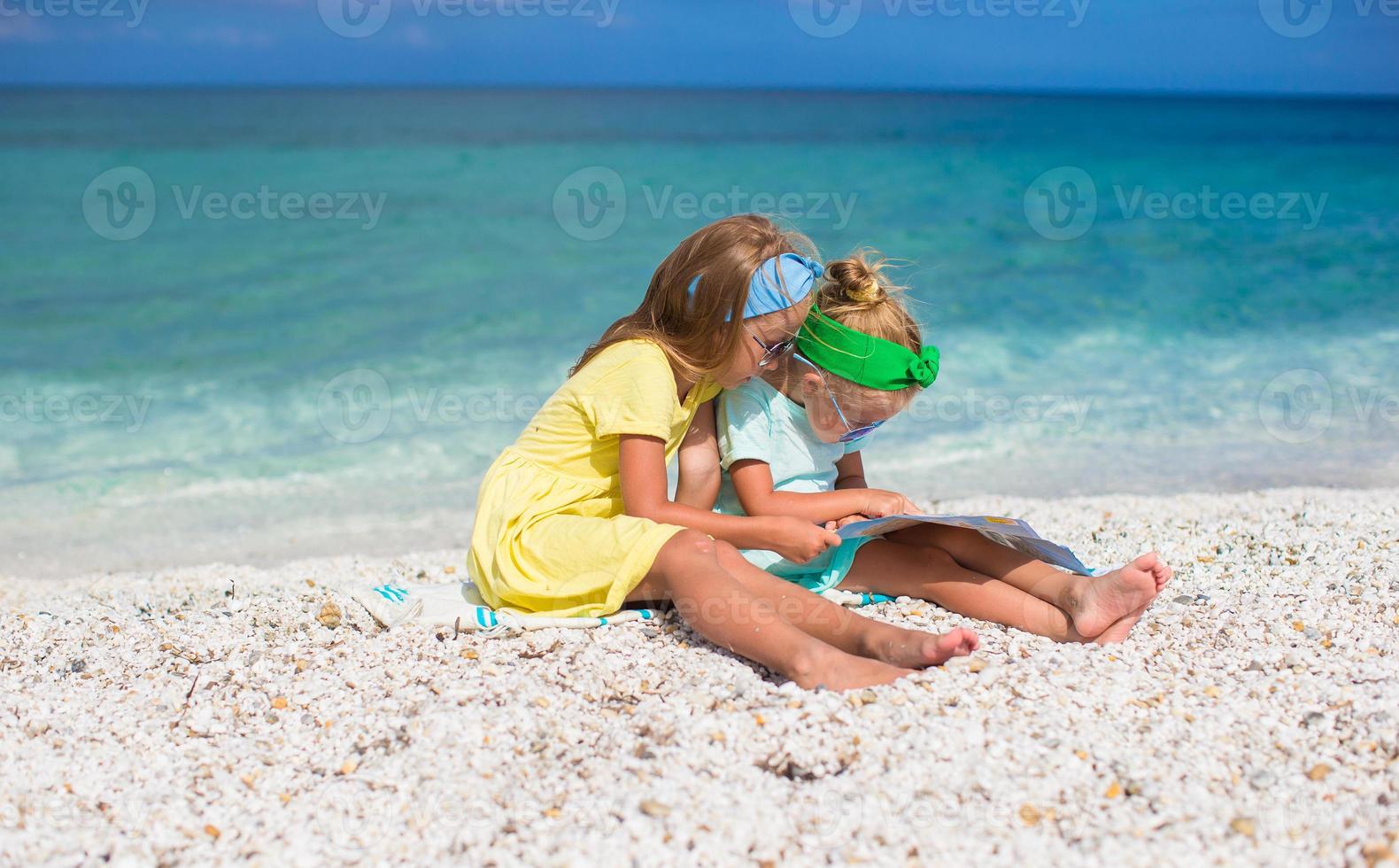 Kleine süße Mädchen mit großer Karte im tropischen Strandurlaub foto