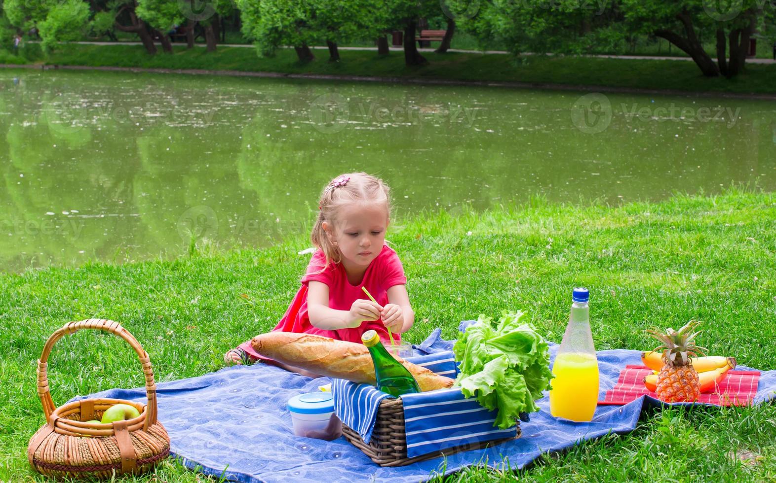 entzückendes kleines mädchen viel spaß beim picknick foto